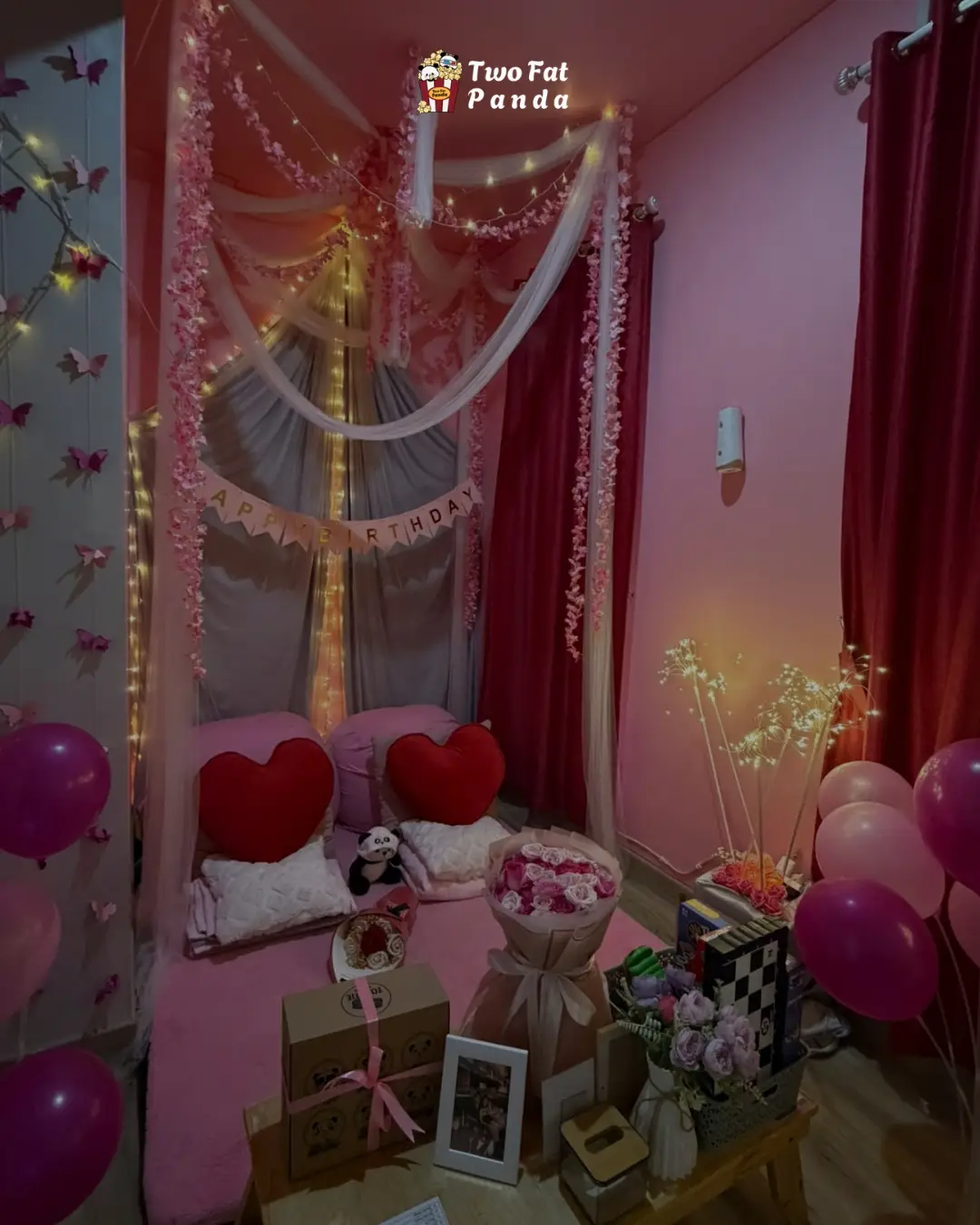 Pink private cinema room decorated with lights, flowers, balloons, and birthday gifts